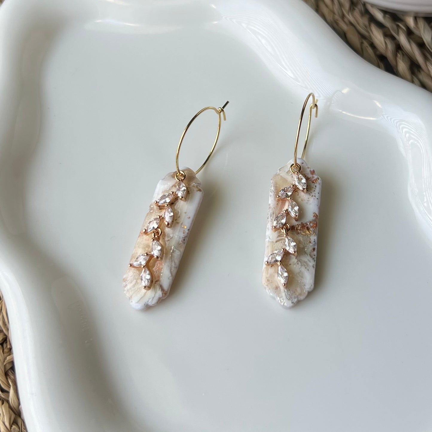 Marbled ivory clay with mixes of gold and silver colors with gold colored stainless steel hoops and cubic zirconia “vine” pendant