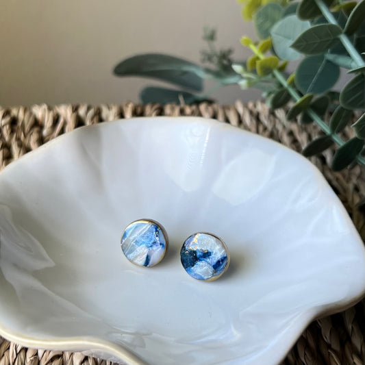 The Marina polymer clay statement circle stud earrings in ocean blue with gold edges, lightweight and coastal-inspired. 