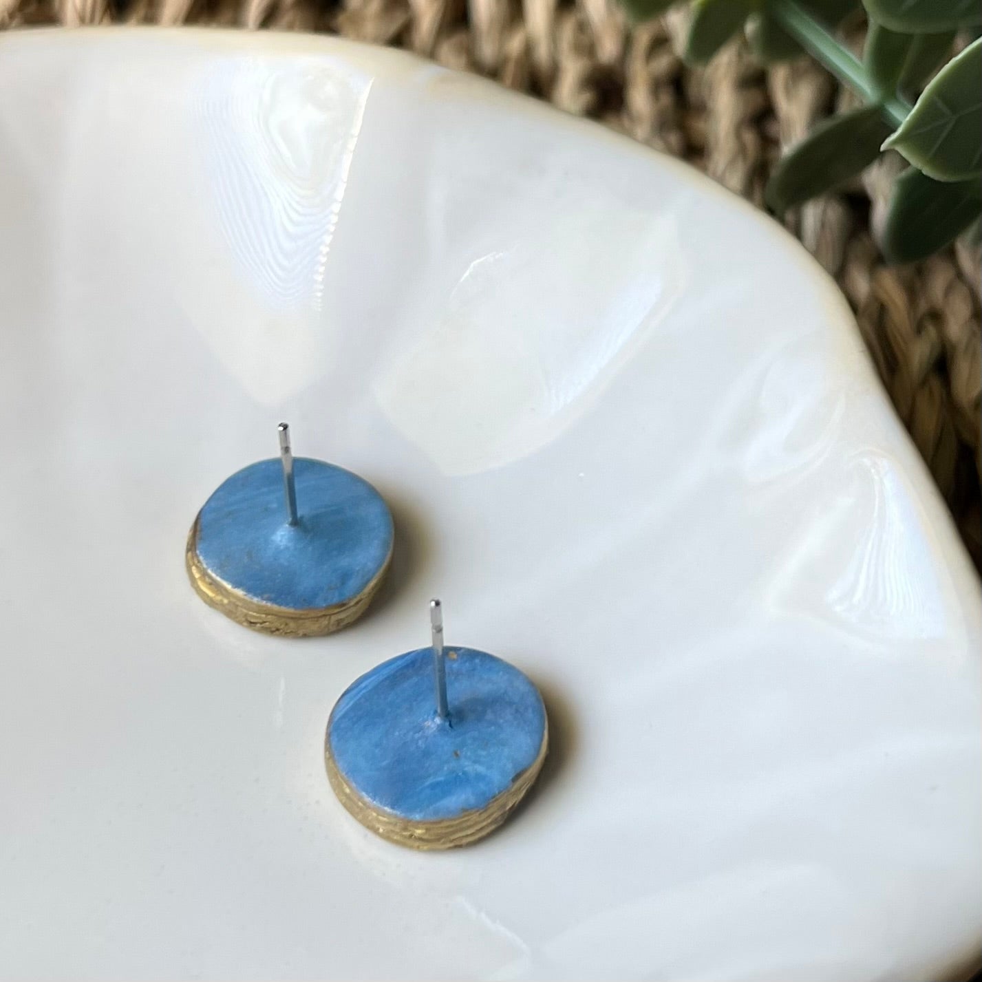 The Marina polymer clay statement stud earrings in ocean blue with gold edges, lightweight and coastal-inspired. Phot shows back of earrings with stainless steel posts embedded with clay for added strength & durability 