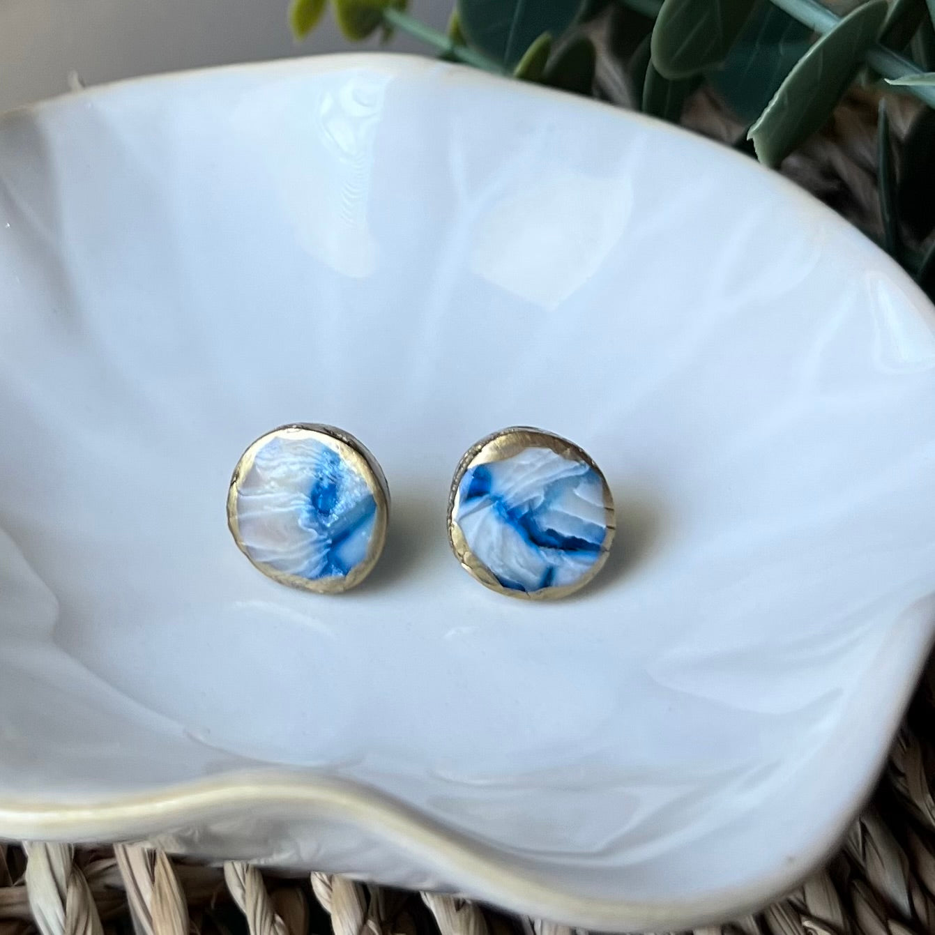 The Marina polymer clay circle stud earrings in ocean blue with gold edges, lightweight and coastal-inspired.