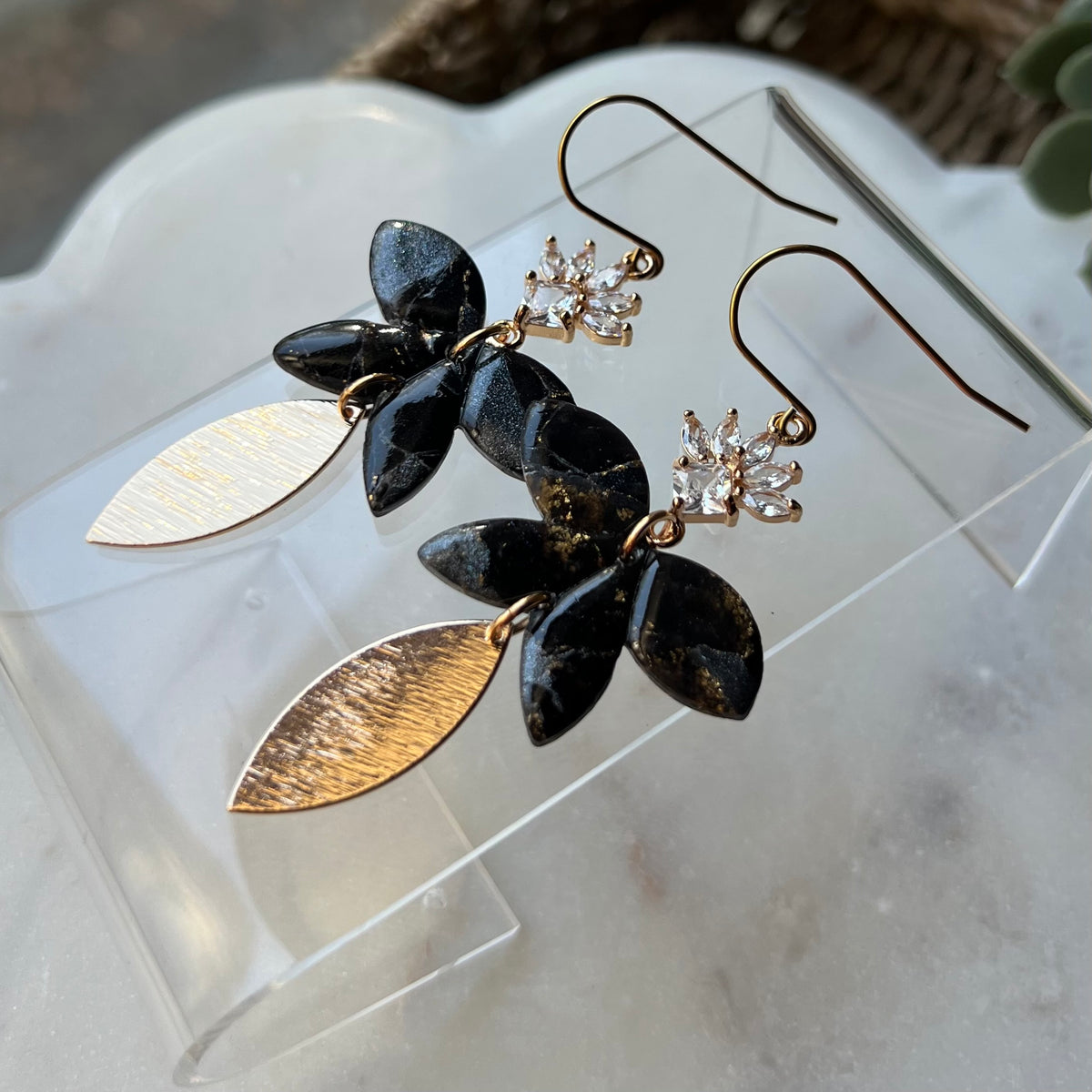 Black floral polymer clay dangle earrings with CZ flower and textured gold leaf