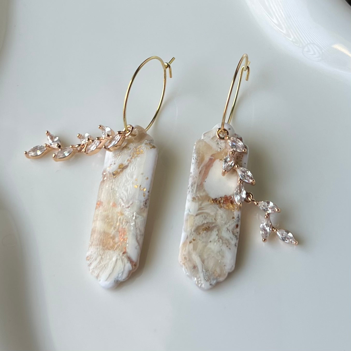 Pair of earrings with stone-like pendants on a white background